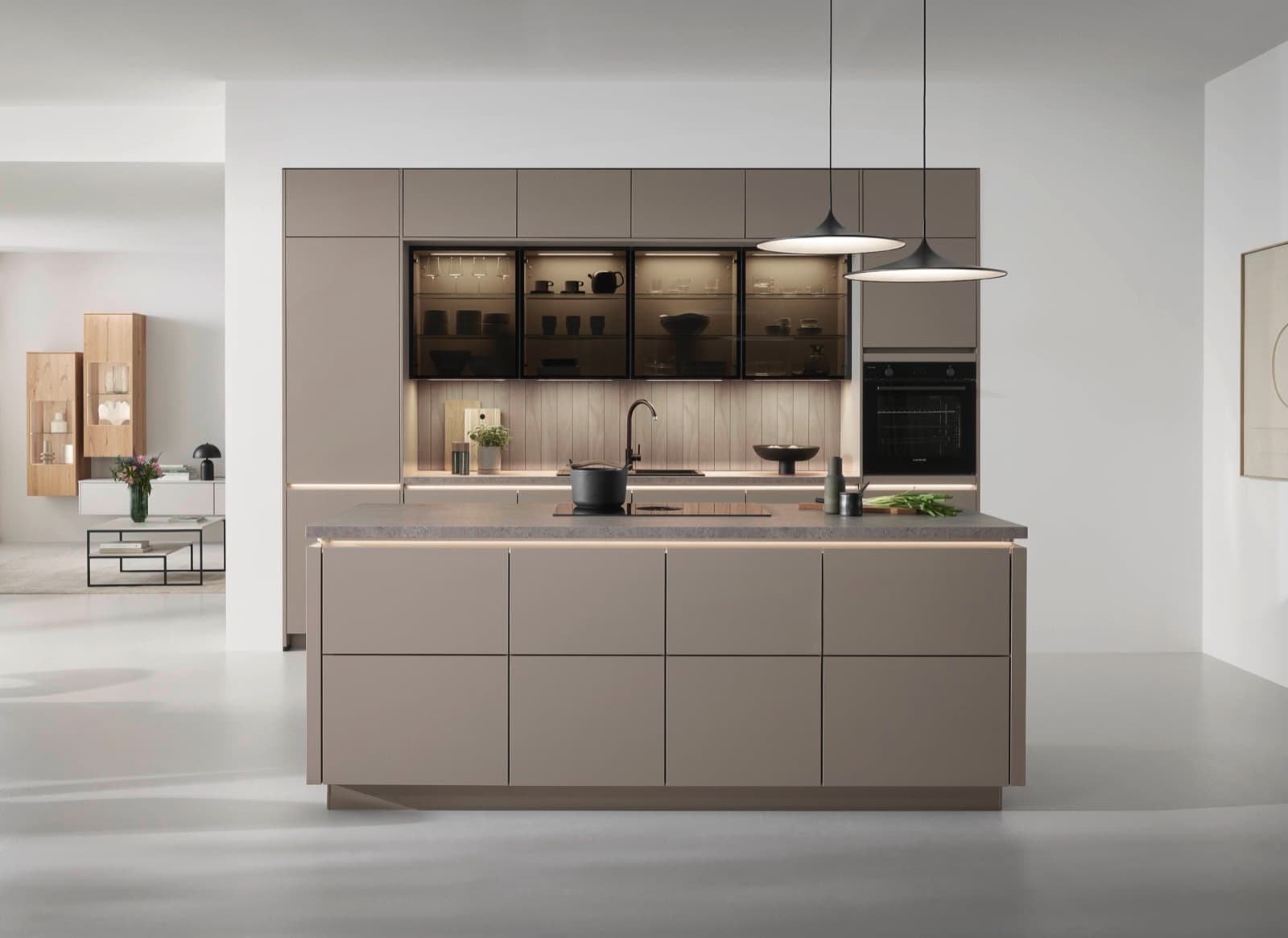 Greeploze taupe keuken met kookeiland en verlichte vitrinekasten